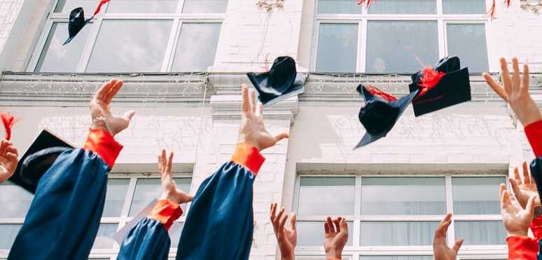 Recent grads throw their caps in the air